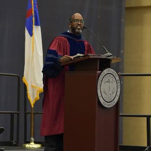 Photo of Gerald Griffin, Provost of Hope College. At podium with Hope College seal. 