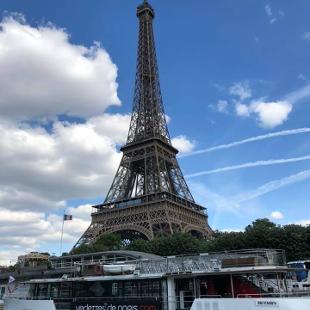 An image of the Eiffel Tower overlooking a river with a boat