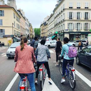 A group of people riding bikes down a street in Paris
